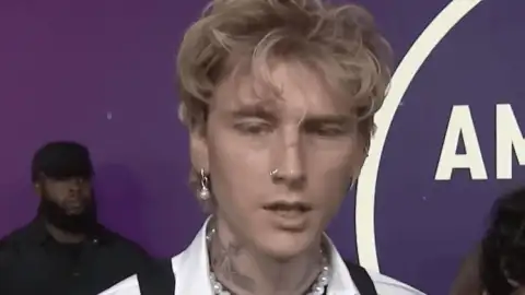 Machine Gun Kelly surge no tapete vermelho do AMA 2025, mas deixa o evento antes de começar